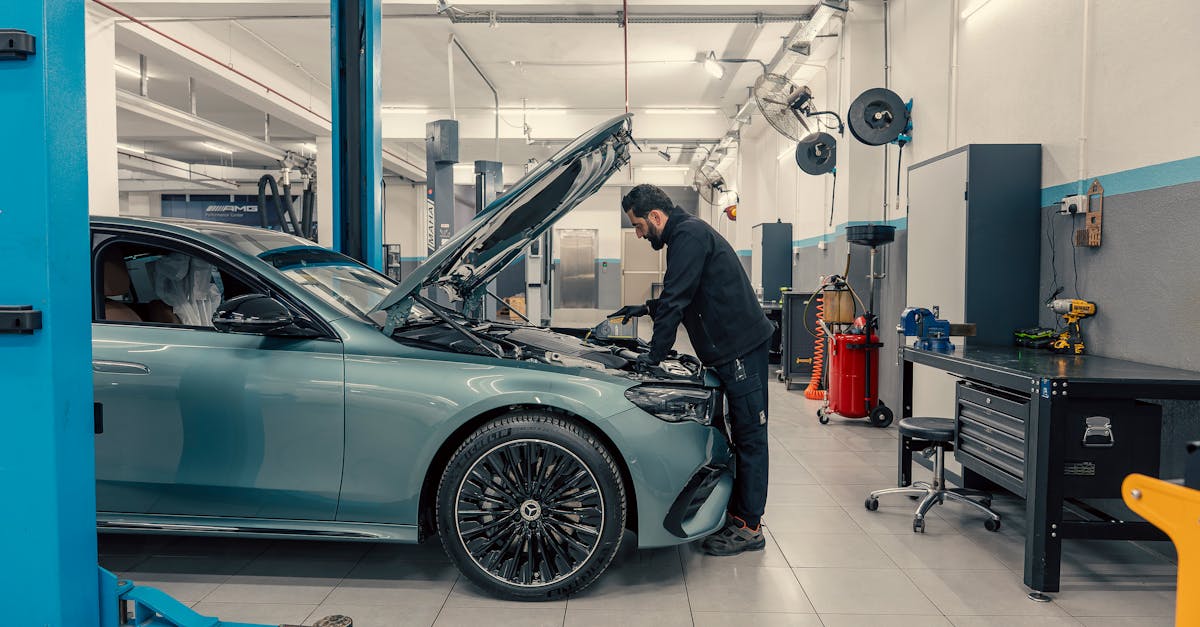Mechanic inspecting a luxury car inside a well-equipped garage. Vehicle maintenance setting.